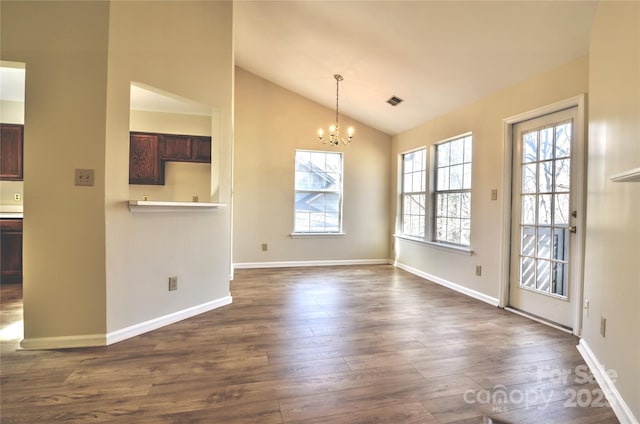 interior space featuring lofted ceiling, dark hardwood / wood-style floors, and an inviting chandelier