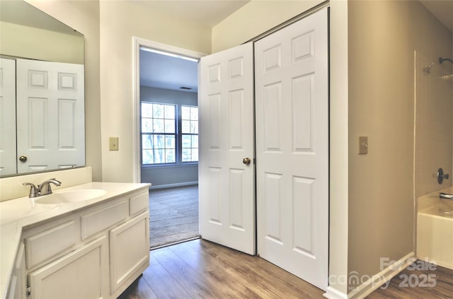 bathroom featuring hardwood / wood-style flooring, vanity, and shower / bathtub combination