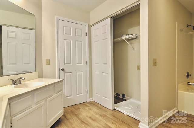 bathroom featuring vanity, hardwood / wood-style floors, and washtub / shower combination