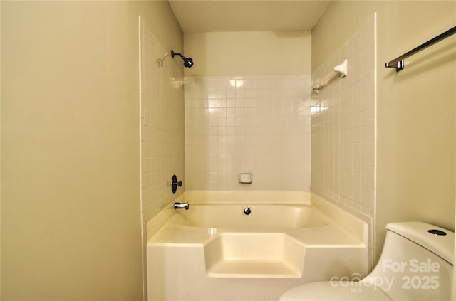 bathroom with tiled shower / bath combo and toilet