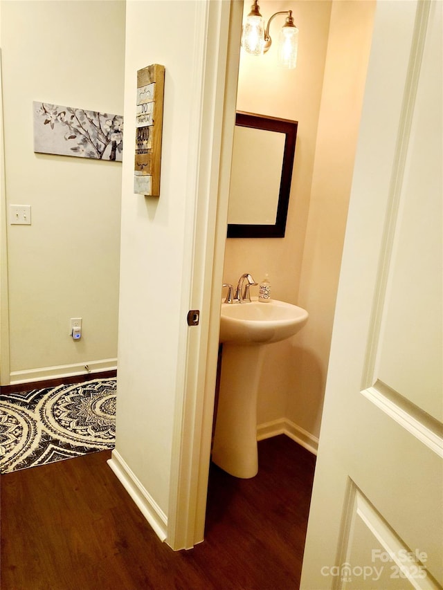 bathroom with wood finished floors, baseboards, and a sink