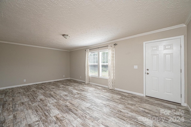 foyer entrance with hardwood / wood-style flooring, ornamental molding, and a textured ceiling