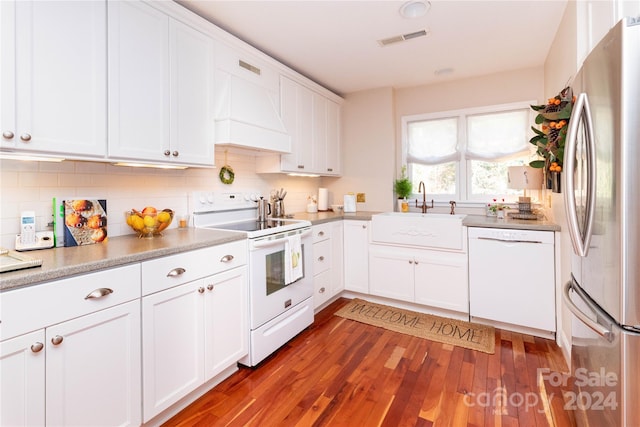 kitchen with sink, white cabinets, dark wood-type flooring, and white appliances