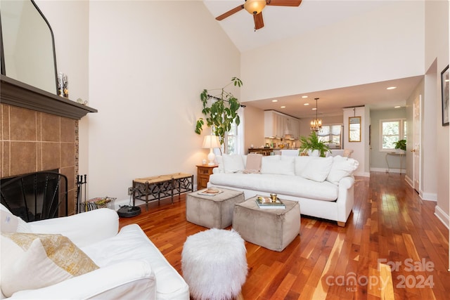 living room with a fireplace, hardwood / wood-style flooring, high vaulted ceiling, and ceiling fan