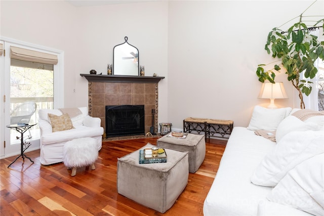 living room with a tiled fireplace and hardwood / wood-style floors