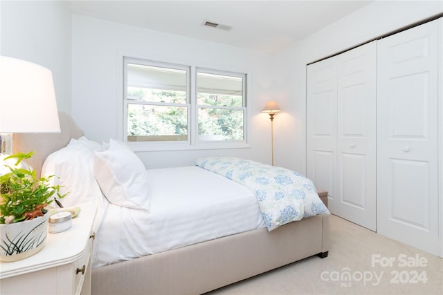 bedroom with light carpet and a closet