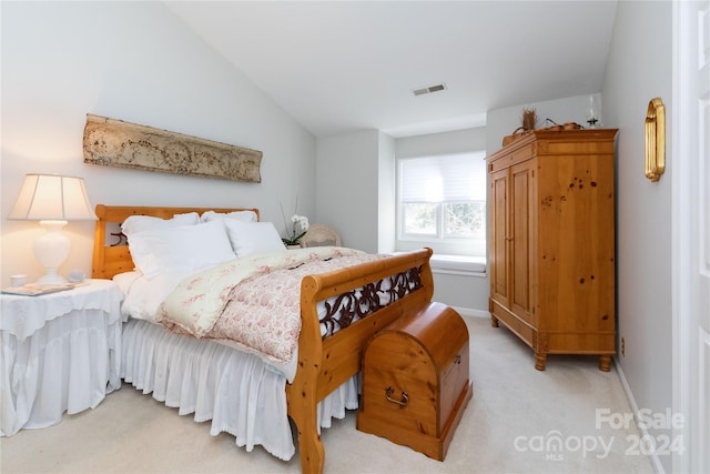 carpeted bedroom with lofted ceiling