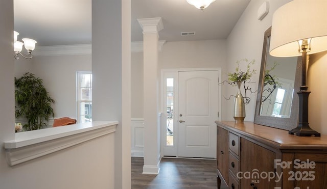 entrance foyer with decorative columns, ornamental molding, and dark hardwood / wood-style floors