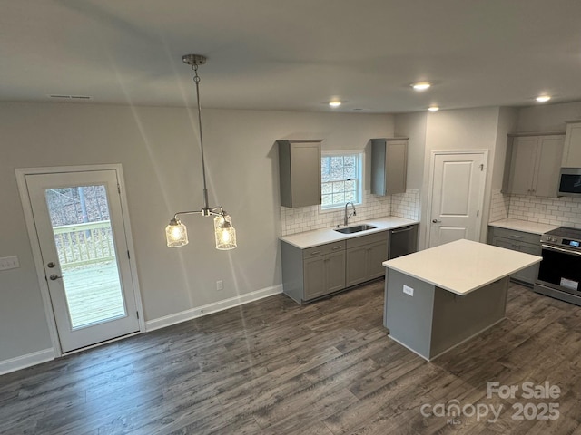 kitchen with sink, gray cabinetry, a center island, pendant lighting, and stainless steel appliances