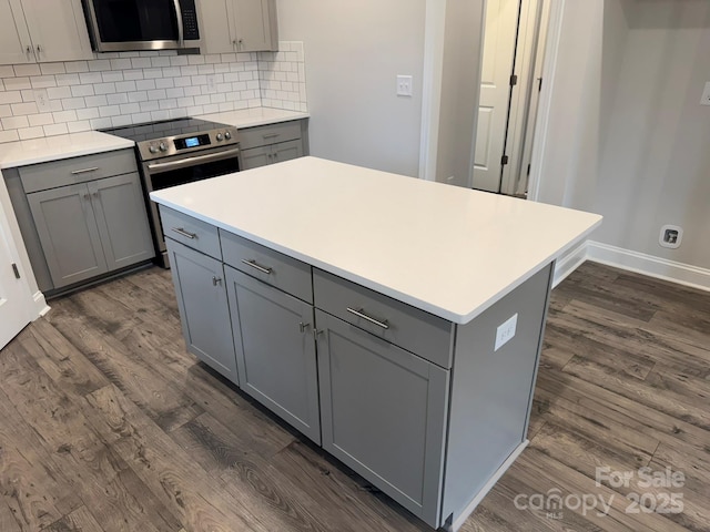 kitchen featuring dark wood-type flooring, stainless steel appliances, and gray cabinetry