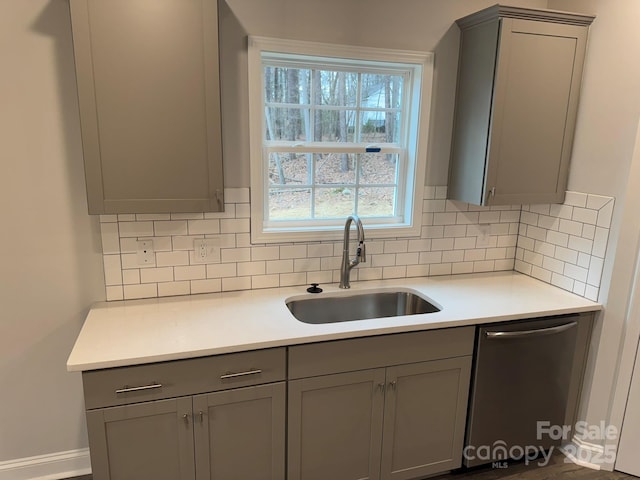 kitchen with sink, gray cabinets, and dishwasher