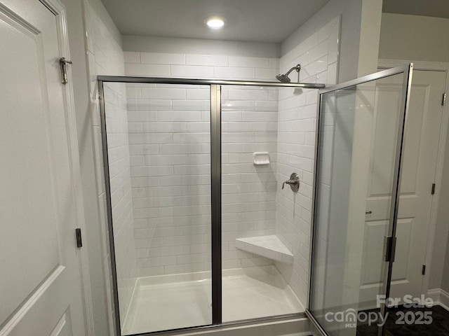 bathroom with a shower with door