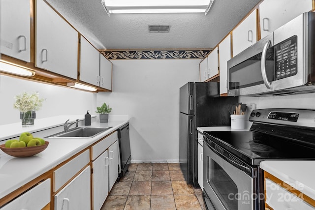 kitchen with white cabinets, sink, stainless steel appliances, and a textured ceiling