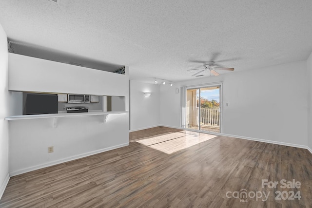 unfurnished living room with dark hardwood / wood-style floors, ceiling fan, and a textured ceiling