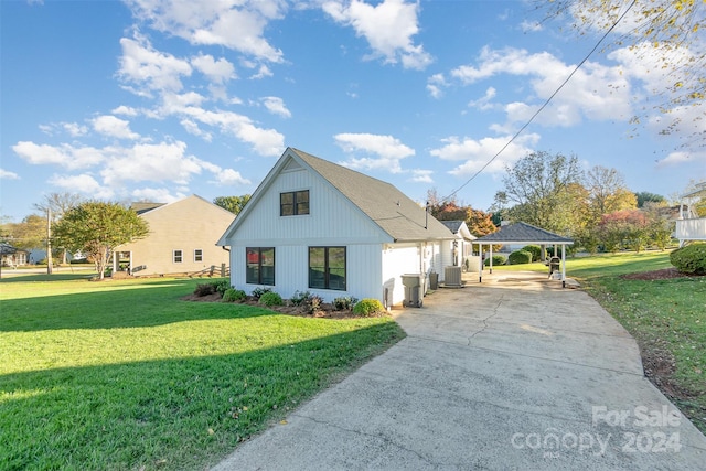 view of front of house with central AC unit, a front yard, and a carport