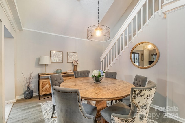 dining space with hardwood / wood-style flooring and crown molding