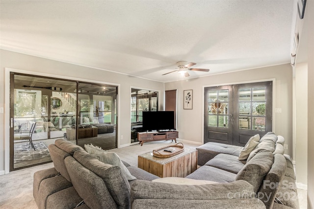 carpeted living room featuring ceiling fan, french doors, and a textured ceiling