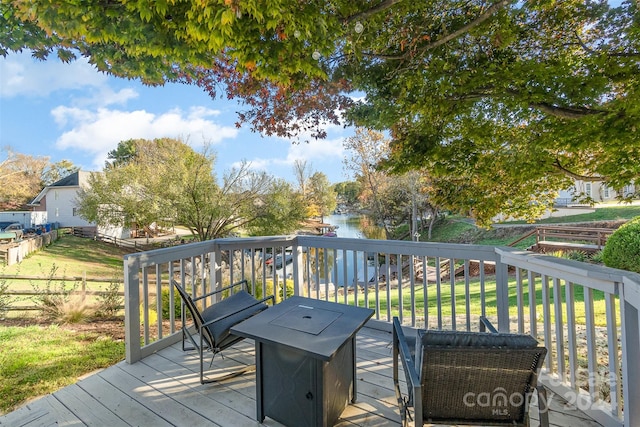 deck with a lawn and a water view