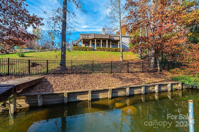 view of dock featuring a yard and a water view