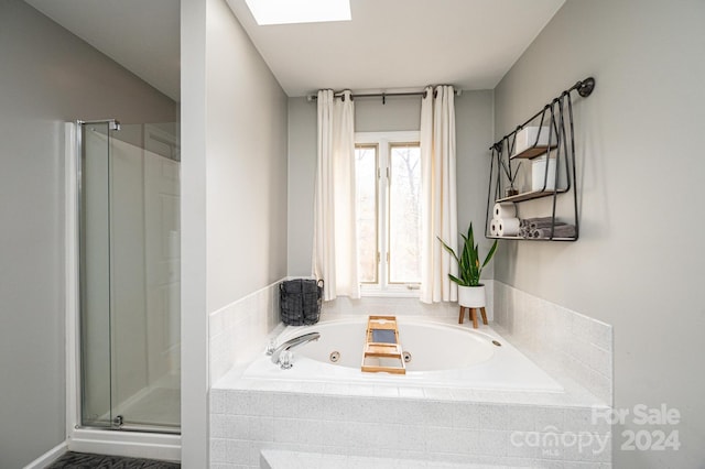 bathroom with shower with separate bathtub and a skylight