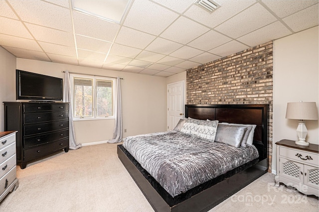 bedroom with light carpet and a drop ceiling