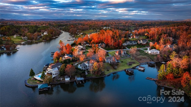 aerial view at dusk featuring a water view