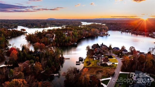 aerial view at dusk featuring a water view