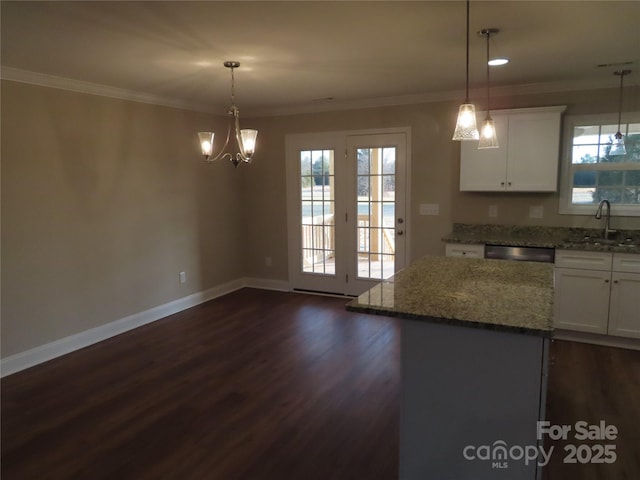 kitchen featuring a center island, sink, hanging light fixtures, and white cabinets