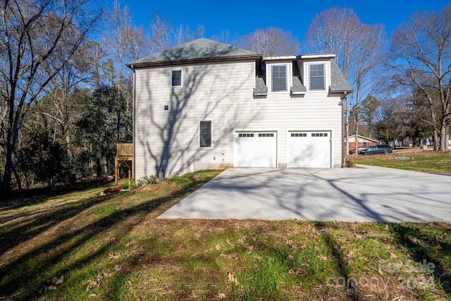 rear view of house with a garage and a yard