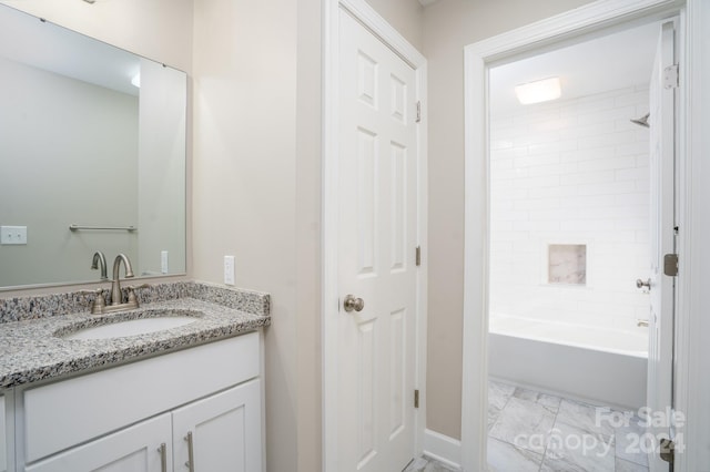 bathroom featuring vanity and tiled shower / bath