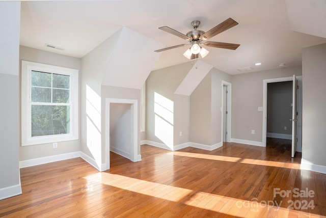 additional living space with light wood-type flooring, vaulted ceiling, and ceiling fan