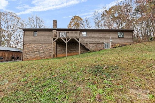 back of property featuring a lawn, cooling unit, and a wooden deck