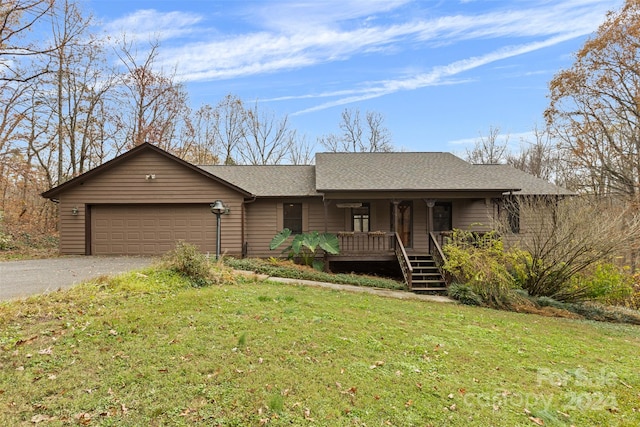 single story home featuring covered porch, a garage, and a front yard