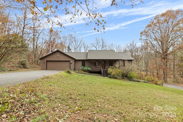 single story home with covered porch, a front yard, and a garage