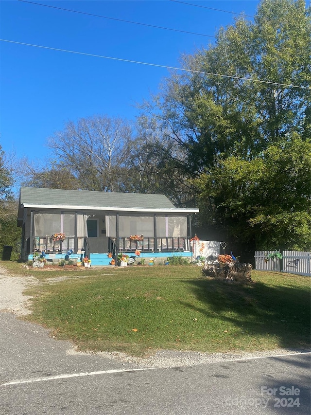 view of front of home with a front lawn and a sunroom