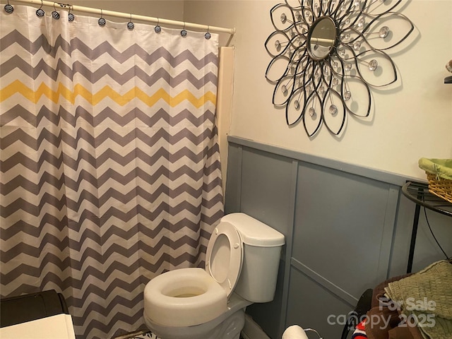 bathroom with toilet and curtained shower