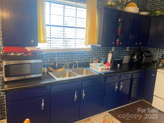 kitchen with sink, backsplash, range with gas cooktop, and blue cabinets