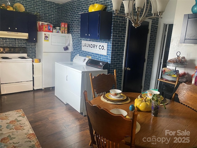 interior space with independent washer and dryer, dark hardwood / wood-style flooring, and tile walls