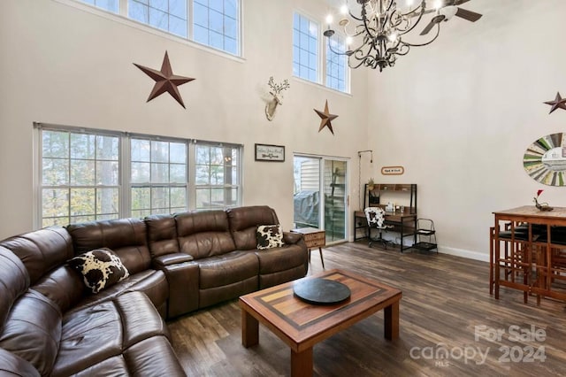 living room featuring dark hardwood / wood-style floors, a healthy amount of sunlight, and a towering ceiling