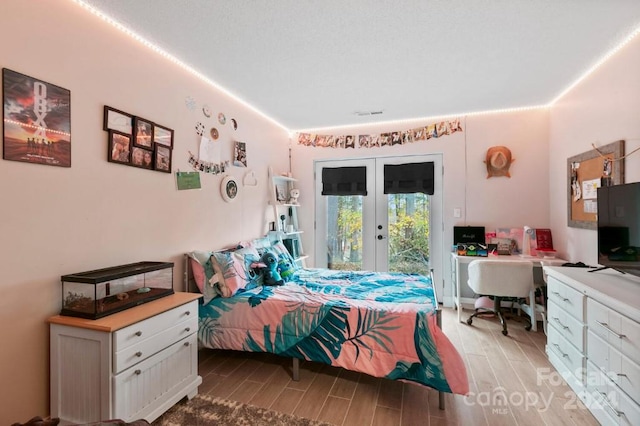 bedroom featuring access to outside, french doors, and light wood-type flooring