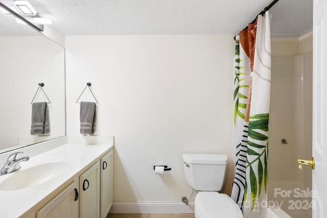 bathroom with vanity, a textured ceiling, toilet, and curtained shower