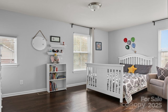 bedroom featuring wood finished floors, visible vents, and baseboards