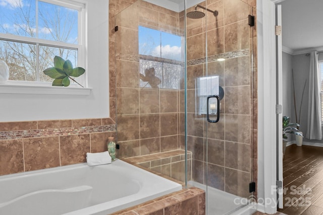 bathroom featuring ornamental molding, a garden tub, and a shower stall