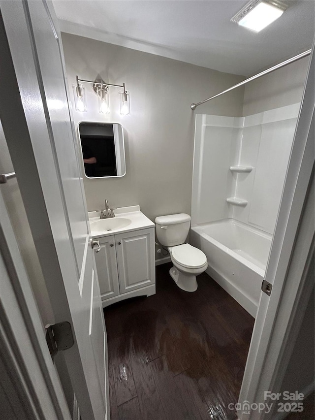 full bathroom with shower / tub combination, vanity, toilet, and wood finished floors