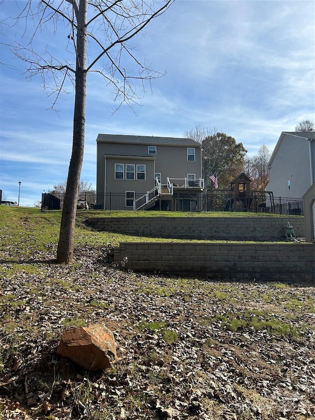 back of house featuring a fenced front yard and a lawn