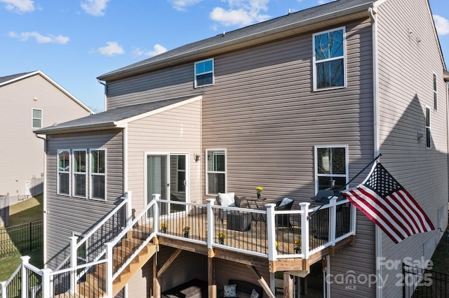 rear view of house with stairway, fence, and a wooden deck