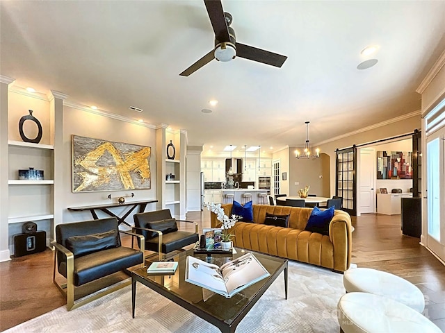 living room with ceiling fan with notable chandelier, built in features, wood-type flooring, and crown molding