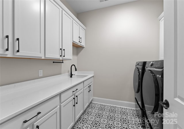 clothes washing area featuring light tile patterned flooring, cabinets, washer and clothes dryer, and sink