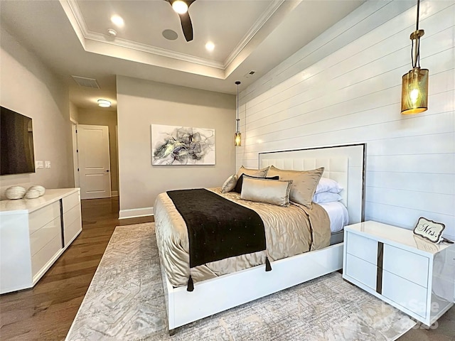 bedroom with hardwood / wood-style floors, crown molding, a raised ceiling, and ceiling fan