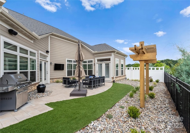 rear view of property with french doors, a patio area, and a lawn